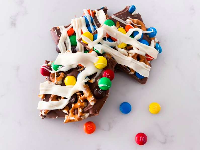 Popular Lifestyle and Beauty Blogger, Kelly Snider, shares an easy Chocolate Bark Recipe; Image of chocolate bark with m&ms and pretzels.