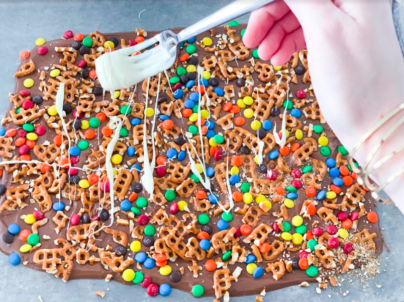 Popular Lifestyle and Beauty Blogger, Kelly Snider, shares an easy Chocolate Bark Recipe; Image of chocolate bark with m&ms and pretzels.