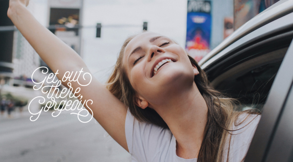 Sell Makeup From Home by popular Utah beauty blogger, Kelly Snider: image of a woman leaning out the passenger window in a car and holding her hand above her head.