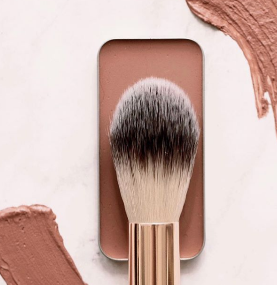 How to Choose Highlight Color by popular Utah beauty blogger, Kelly Snider: image of a Maskcara makeup brush and a Maskcara highlight tin. 