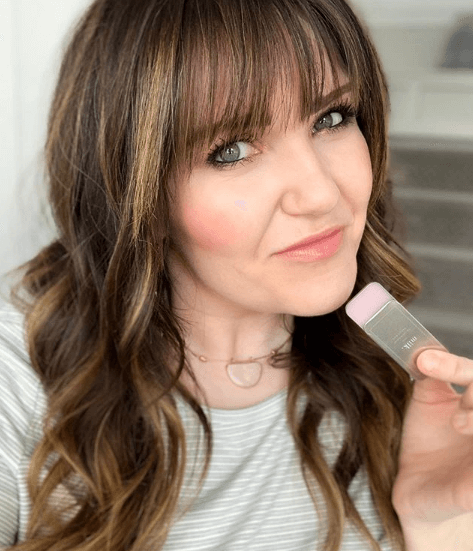 Office Makeup by popular Utah beauty blogger, Kelly Snider: image of a woman holding Maskcara Milk lip conditioner. 