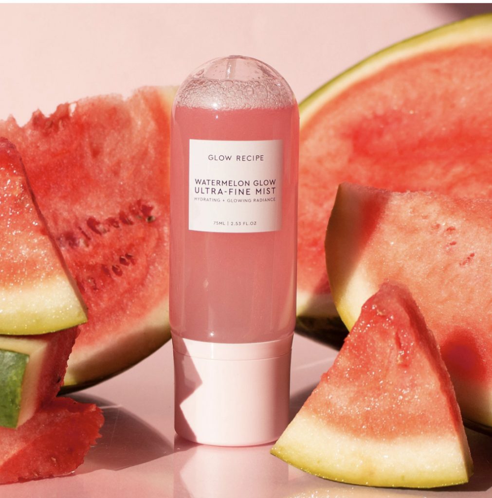 Top 3 Summer Beauty Staples by Popular Utah Beauty Blogger and Top Maskcara Beauty Artist, Kelly Snider; Image of watermelon glow mist amongst actual watermelon slices.