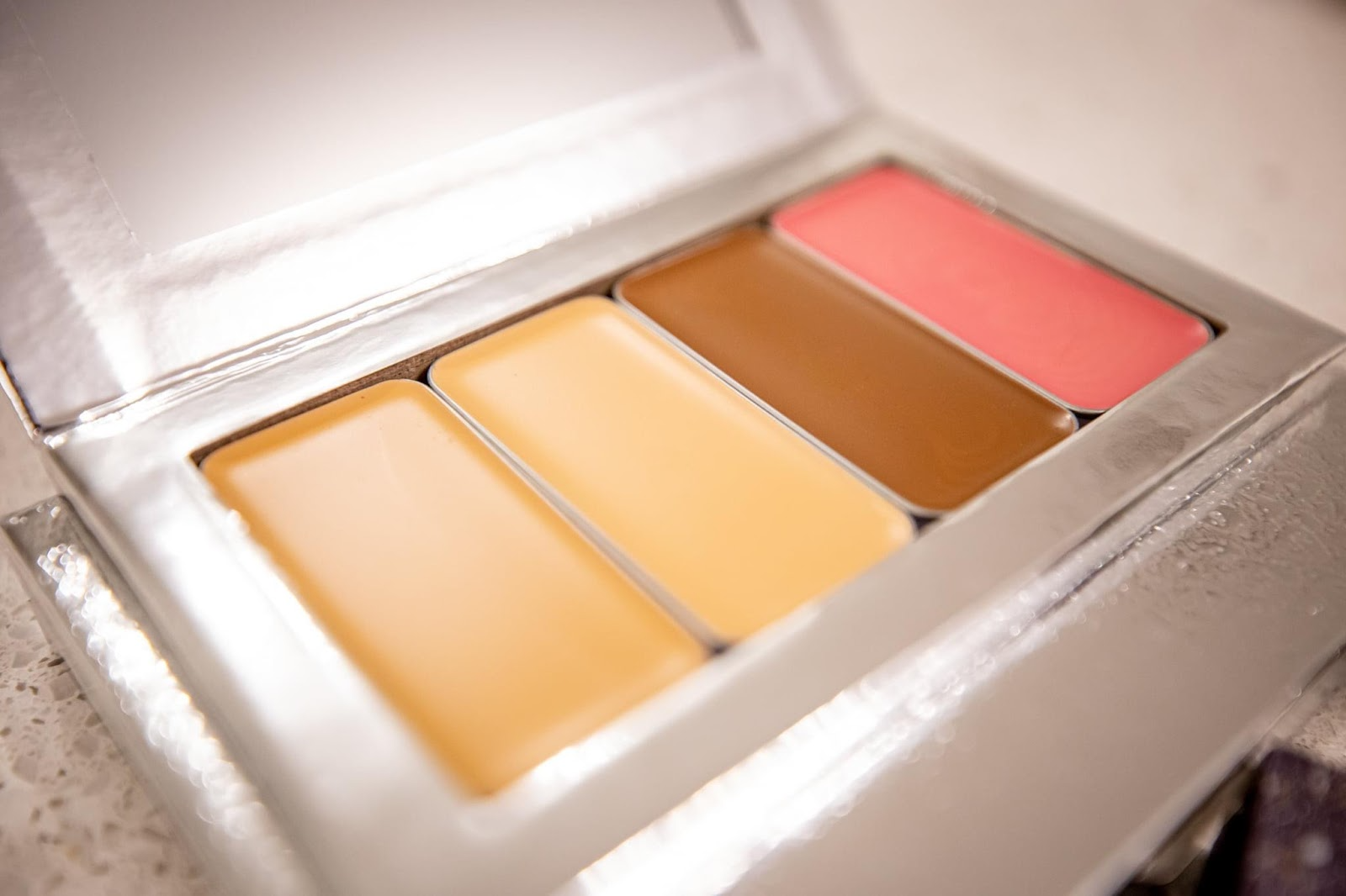 Picture of 4 different shades of makeup that create a Seint's IIID Foundation palette that can be used to learn how to color correct properly. 