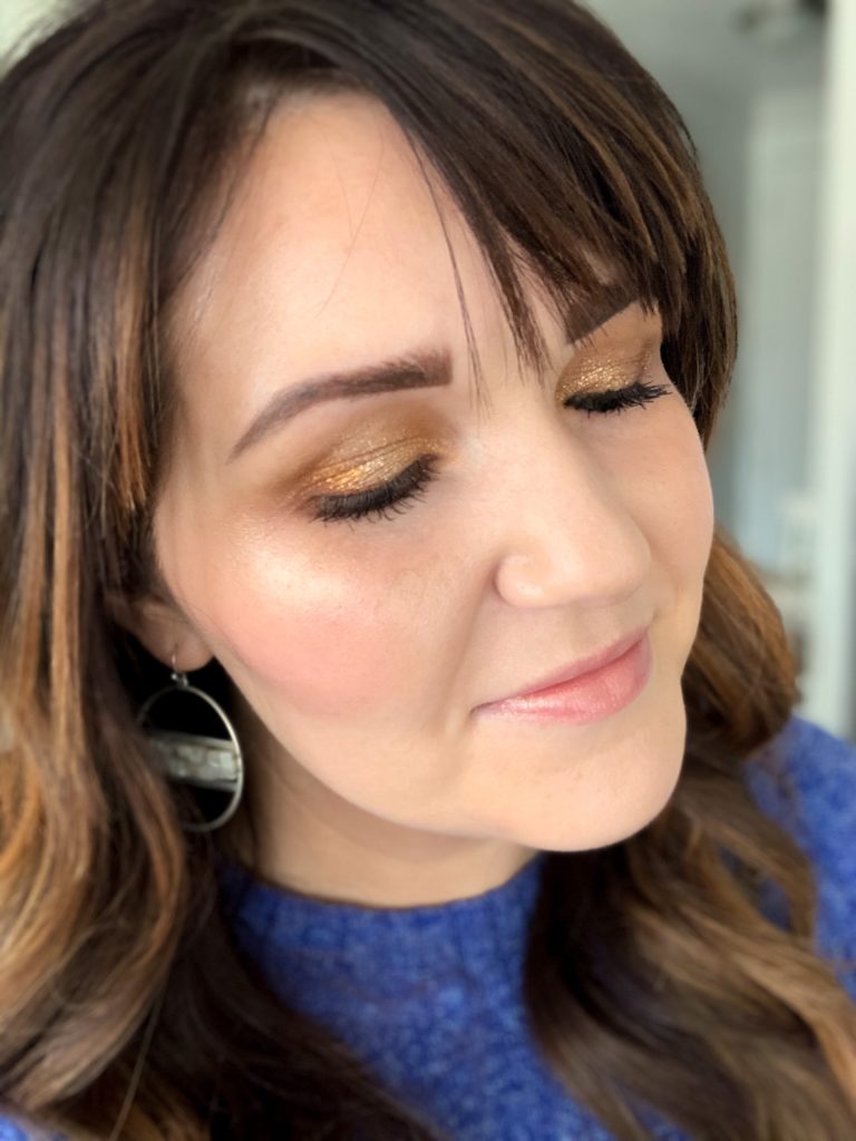 Kelly Snider demonstrating a gold eye shadow look 